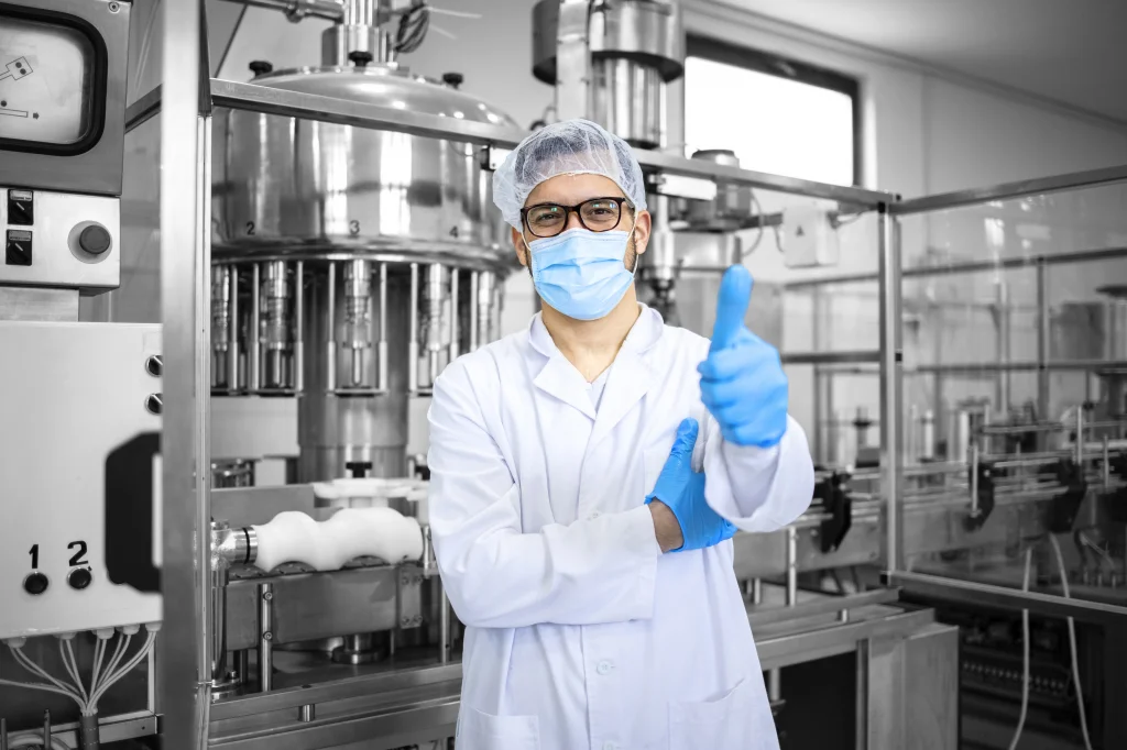 Zuversichtlicher Ingenieur in Laborkleidung gibt mit einem Daumen hoch ein positives Signal in einer modernen, automatisierten Produktionsumgebung. Dieses Bild repräsentiert die Expertise und das Engagement von CTE, massgeschneiderte und zukunftsfähige Automatisierungslösungen durch partnerschaftliche Zusammenarbeit und tiefgreifendes Fachwissen zu liefern.